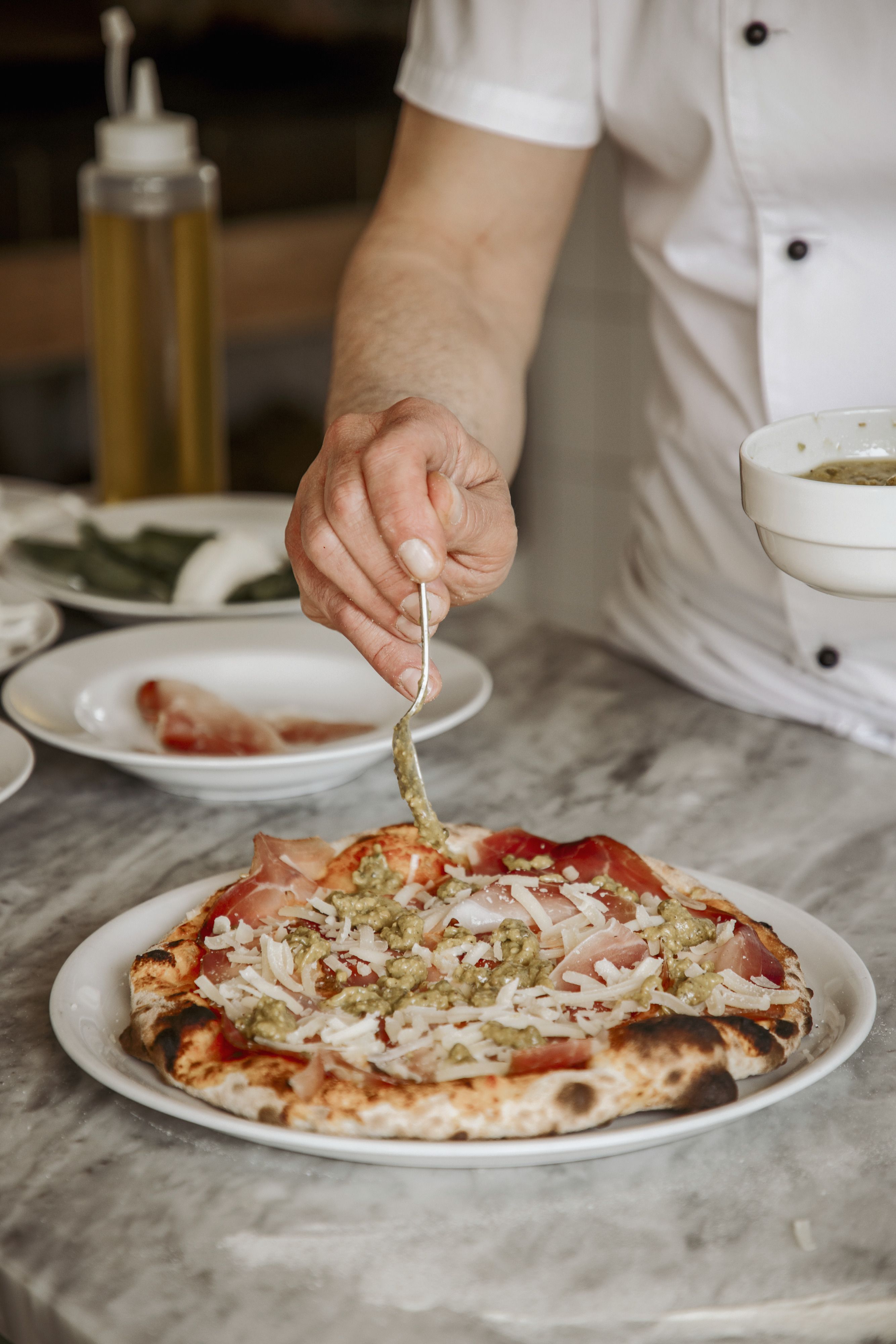 Pesto di pistacchio versato sulla pizza