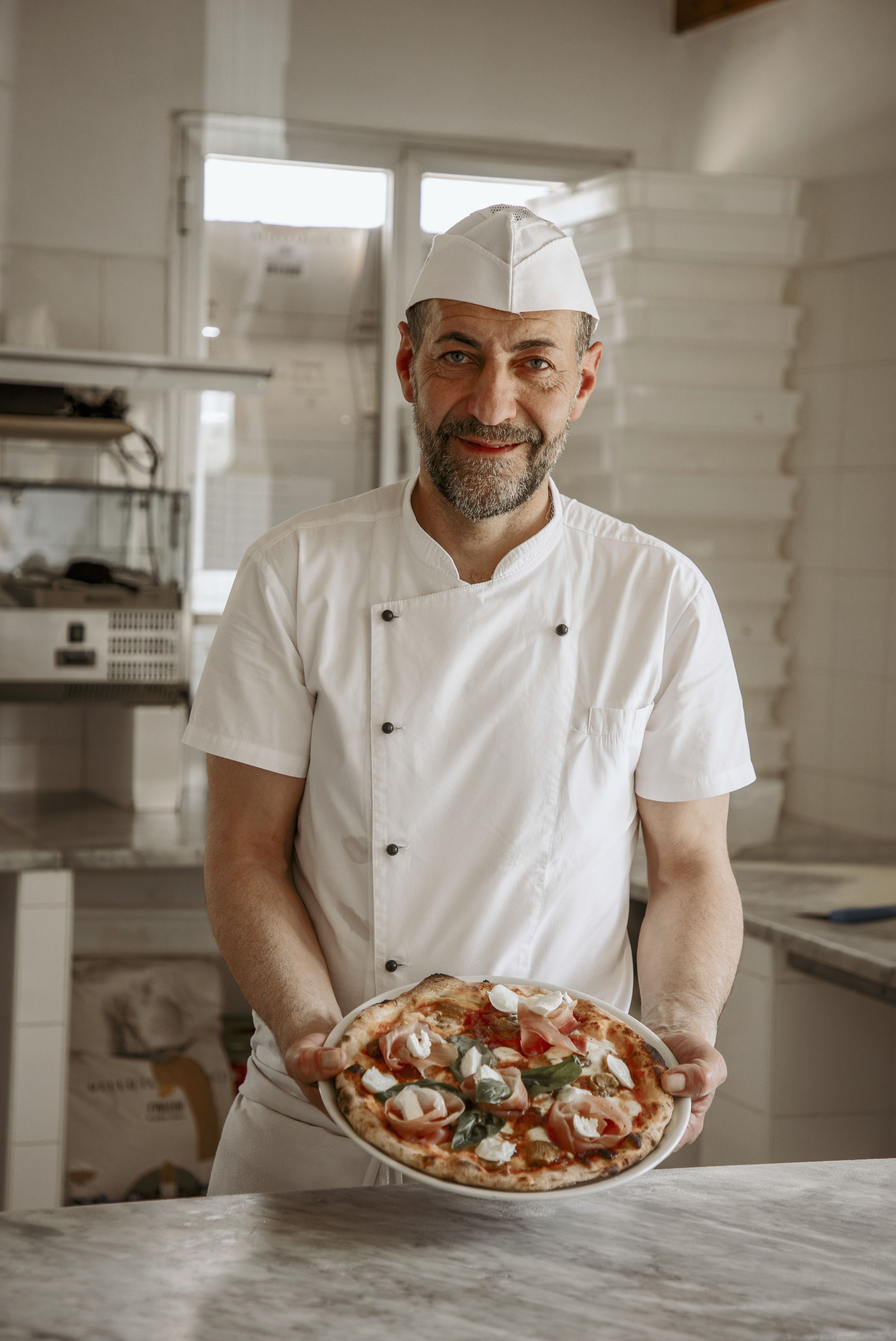 Il pizzaiolo con una pizza
